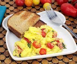 SCRAMBLED EGGS WITH TOMATOES AND RED ONIONS AND 2 TOAST ON THE SIDE