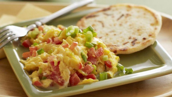 AREPAS WITH SCRAMBLED EGGS, ONIONS, TOMATOES AND 1 BACON STRIP ON  THE SIDE