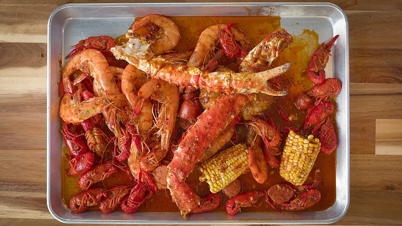 Cooked crawfish with ice and fishing net on a wooden tray. Stock