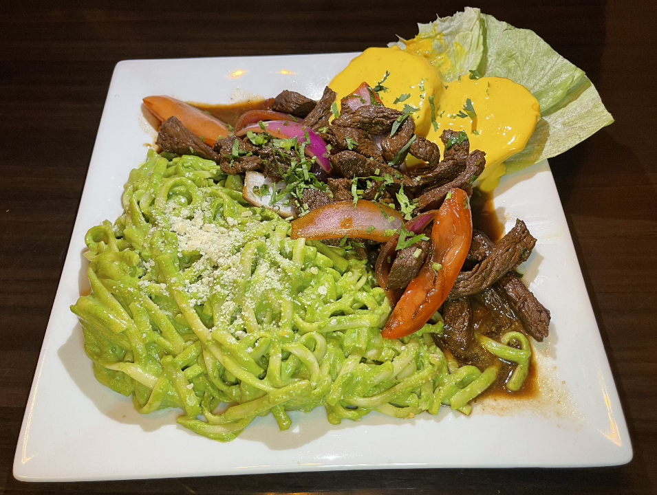 TALLARIN VERDE CON LOMO Y PAPA A LA HUANCAINA / GREEN SPAGHETTI WITH STIR-FRY AND YELLOW SAUCE OVER POTATOES