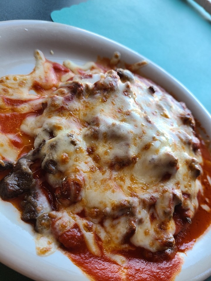 ONE TOSTADA COVERED IN SAUCE AND MELTED CHEESE