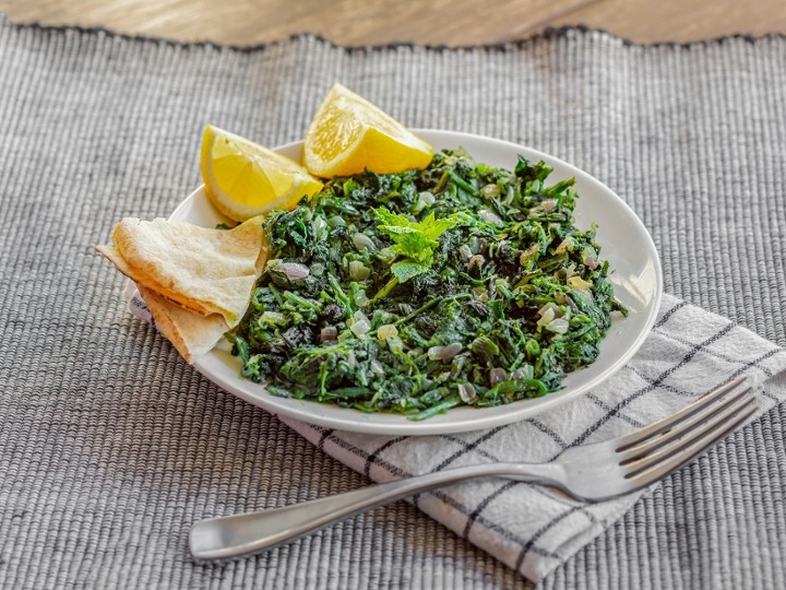 HINDEBEH "BOILED DANDELION LEAVES COOKED WITH ROASTED GARLIC SERVED WITH LEMON WEDGES)