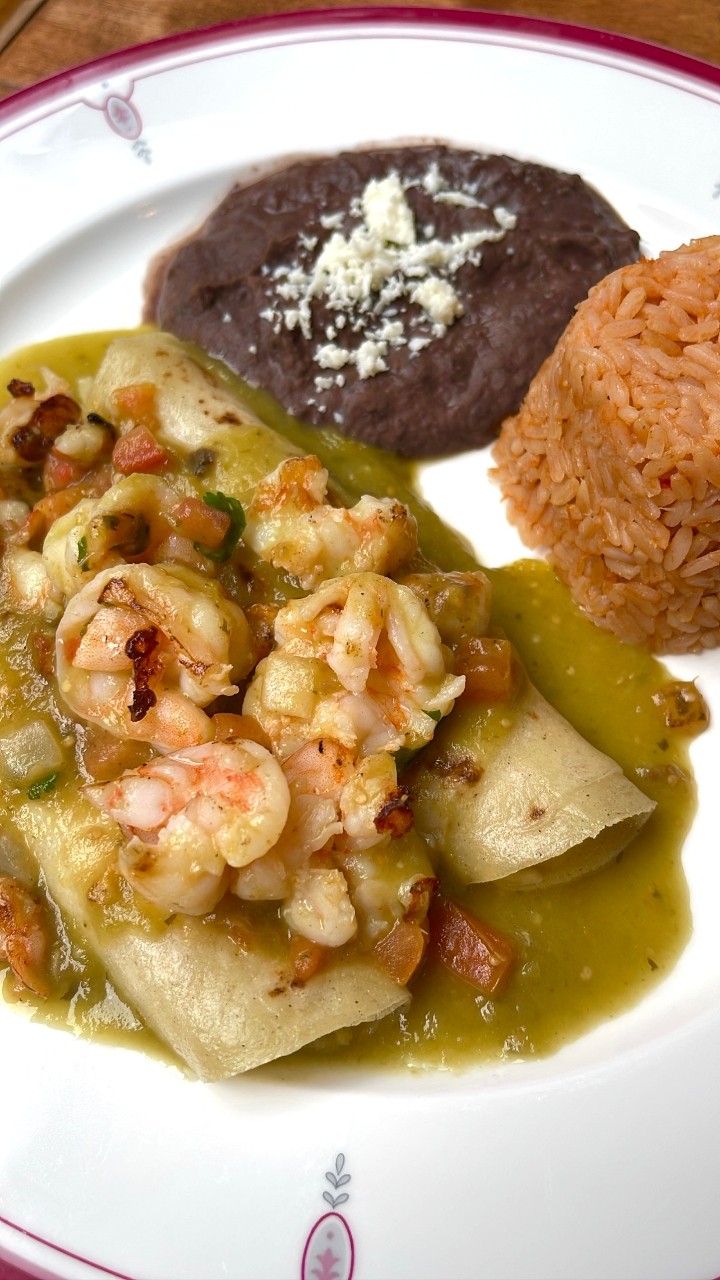 Green Shrimp Enchiladas / shrimps are on top and filled with cheese.