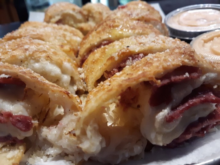OHIO seasoned corned beef, thousand island dressing, sauerkraut, mozzarella rolled in our crust and brushed with garlic butter.  Side of Thousand Island Dressing.