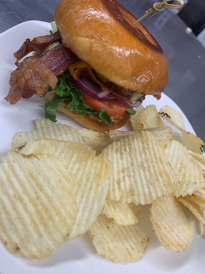 Bacon Cheddar Burger (Local, grass fed beef burger with Bacon, Cheddar, Lettuce, Tomato, and Red Onion) served with chips