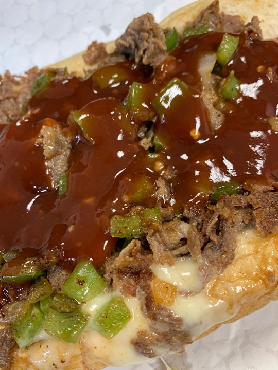 (12oz) Mumbo Philly cheesesteak with peppers onions and a generous amount of Mumbo sauce (12oz of meat on a Amoroso roll )