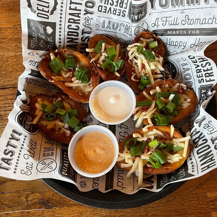 Loaded Potato Skins, 6 potato skins topped with queso, shredded Monterey jack, green onions, & bacon crumbles
