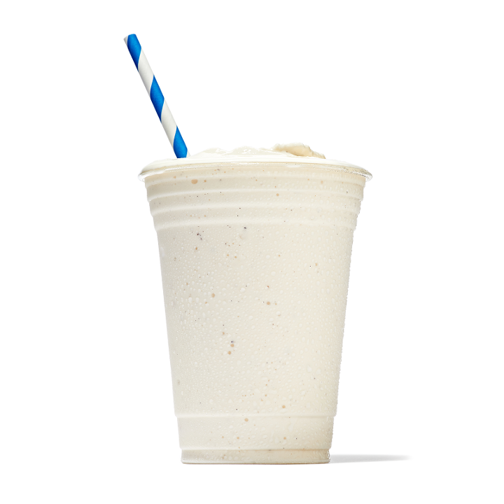 Vanilla Milkshake in Plastic Glass on a Dark Background. Vanilla